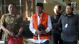 Bupati Kudus, Muhammad Tamzil (tengah) digiring petugas usai menjalani pemeriksaan terkait dugaan suap pengisian jabatan perangkat daerah di lingkungan Pemkab Kudus, Gedung KPK Jakarta, Sabtu (27/7/2019). KPK menyita barang bukti uang sebesar Rp170 juta. (Liputan6.com/Helmi Fithriansyah)