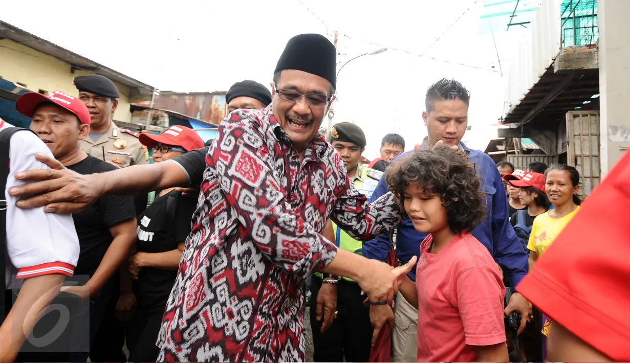 Cawagub petahana, Djarot Syaiful Hidayat menyalami seorang anak saat sosialisasi di kawasan Pademangan VIII, Jakarta, Kamis (23/3). Selain sosialisasi dengan warga, Djarot juga menyerap keluhan warga sekitar. (Liputan6.com/Helmi Fithriansyah)  
