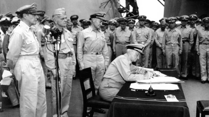 Panglima Armada Pasifik dan Wilayah Samudra Pasifik Laksamana Chester W. Nimitz menandatangani penyerahan Jepang di atas kapal perang USS Missouri, Teluk Tokyo, 2 September 1945. Tanggal 2 September 2020 menjadi peringatan 75 tahun penyerahan resmi Jepang kepada Amerika Serikat. (AP Photo, File)