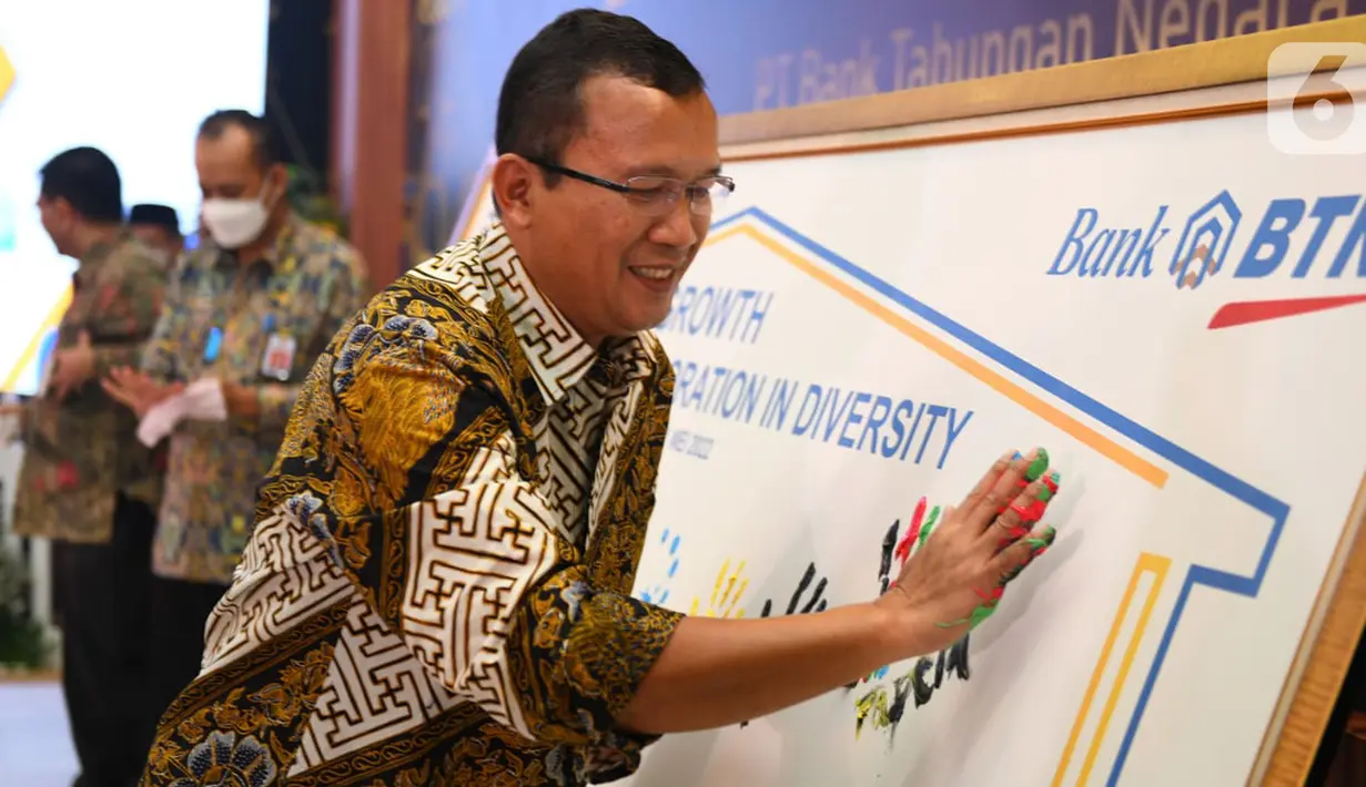 Direktur Utama Bank BTN Haru Koesmahargyo membubuhkan cap telapak tangan pada acara Halal Bihalal Bank BTN dengan Stakeholder dari Asosiasi Pengembang, Kementerian PUPR, Kementerian Keuangan, BP Tapera dan PT Sarana Multigriya Finansial (SMF) di Jakarta, Rabu (11/5/2022). Pembubuhan cap telapak tangan merupakan simbolik dari komitmen Bank BTN dan stakeholder dalam berkolaborasi membangun rumah rakyat dengan tema "Growth Through Collaboration in Diversity”. (Liputan6.com/HO/BTN)