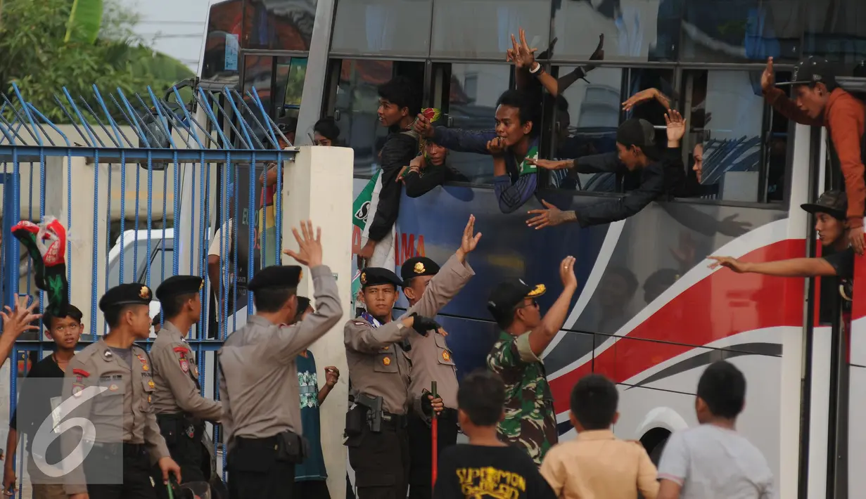 Suporter Persebaya 1927 atau Bonek berteriak dari dalam bus di Stadion Tugu, Jakarta, Rabu (3/8). Bonek menyerbu Jakarta sejak Selasa (2/8) untuk mendesak diagendakannya pengakuan klub Persebaya 1927 pada KLB PSSI. (Liputan6.com/Helmi Fithriansyah)