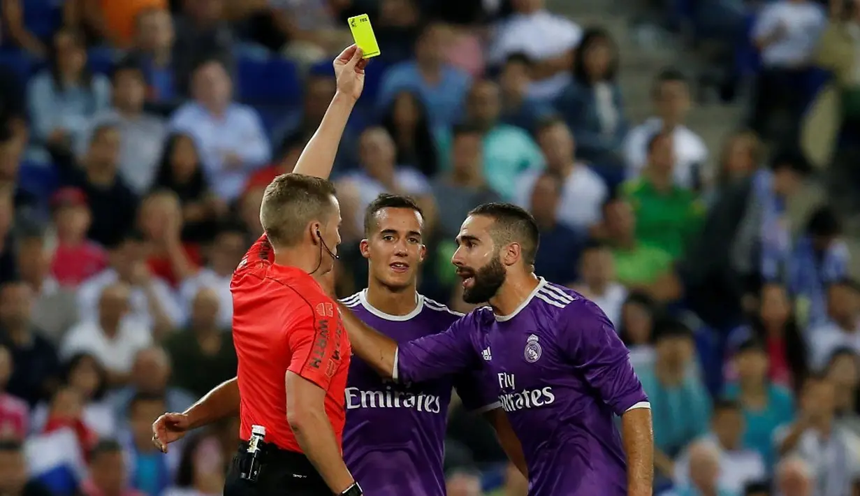 Pemain Real Madrid, Dani Carvajal (kanan), mendapat kartu kuning saat melawan Espanyol pada laga La Liga 2016-2017 di Estadio Cornella-El Prat, Senin (19/9/2016) dini hari WIB. (AFP/Pau Barrena)