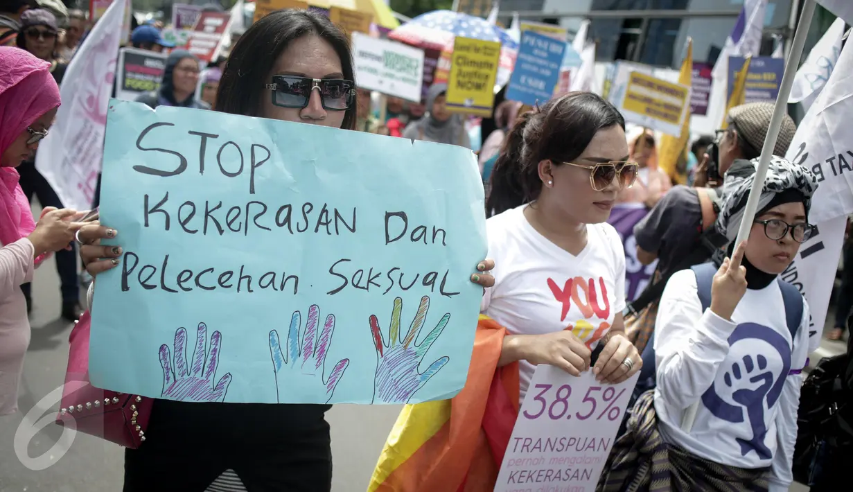Seorang wanita membentangkan poster saat menggelar unjuk rasa dikawasan Patung Kuda, Jakarta, Rabu (8/3). Aksi tersebut dilakukan untuk memperingati hari perempuan Internasional yang jatuh pada hari Rabu tanggal 8 Maret 2017. (Liputan6.com/Faizal Fanani)