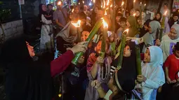 Kegiatan berlangsung meriah dengan partisipasi warga sekitar yang turut mendampingi sepanjang rute pawai. Tampak dalam foto, anak-anak saat mengikuti pawai obor di kawasan Cinere,  Depok, Senin (16/2/2026). (merdeka.com/Arie Basuki)