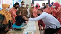 Kepala BKKBN dr hasto Wardoyo (batik cokelat) bersama CEO PTPN V Riau Jatmiko Santosa menyaksikan penimbangan berat badan bayi dalam kegiatan menekan angka stunting di Riau. (Liputan6.com/M Syukur)