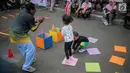 Anak-anak bermain permainan tradisional ditemani sejumlah mahasiswa dari Penggerak Olahraga saat car free day (CFD) di kawasan Bundaran HI, Jakarta, Minggu (14/7/2019). Kegiatan yang rutin digelar ini bertujuan mengajak masyarakat DKI Jakarta aktif berolahraga. (Liputan6.com/Faizal Fanani)