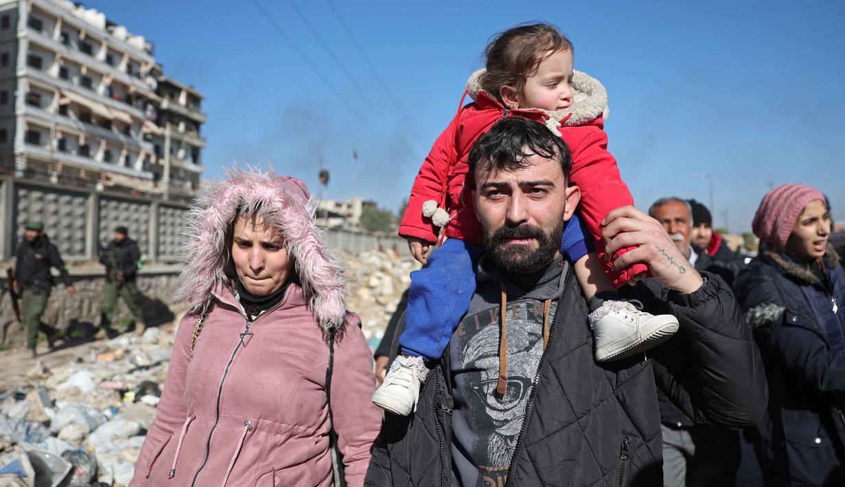 Warga lingkungan Sheikh Maqsud dievakuasi dari zona berbahaya oleh anggota pasukan keamanan pemerintah Suriah, di Aleppo pada Sabtu 10 Januari 2026. Gelombang evakuasi besar-besaran warga sipil dari lingkungan Sheikh Maqsoud dan Ashrafieh di Aleppo, Suriah, terus berlanjut. (OMAR HAJ KADOUR/AFP)