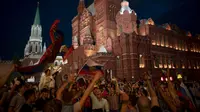 Suporter Rusia berpesta merayakan keberhasilan negaranya mengalahkan Spanyol pada laga 16 besar Piala Dunia di Moskow, Minggu (1/7/2018). Rusia untuk pertama kalinya lolos ke babak perempatfinal. (AFP/Victor Caivano)