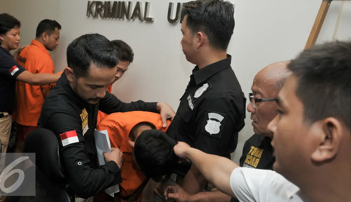 Petugas menggiring pelaku perampokan di Pondok Indah saat rilis di Polda Metro Jaya, Jakarta, Kamis (8/9). Polda Metro gelar rilis pelaku dan sejumlah barang bukti perampokan di Pondok Indah. (Liputan6.com/Yoppy Renato)