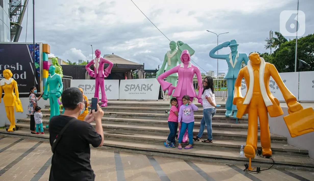 Wisatawan berfoto saat mengunjungi Senayan Park, Jakarta, Rabu (9/12/2020). Libur Nasional Pilkada Serentak 2020 dimanfaatkan sebagian warga Jakarta dan sekitarnya untuk mengunjungi tempat rekreasi bersama keluarga. (Liputan6.com/Faizal Fanani)