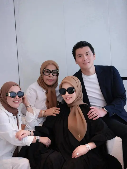 Berpose di sebuah ruang dan duduk di sofa, keduanya kompak mengenakan outfit bernuansa gelap. [Foto: Instagram/princessyahrini]
