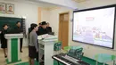 Pemimpin Korea Utara Kim Jong-Un melihat layar saat mengunjungi Universitas Guru Pyongyang yang baru direnovasi di Pyongyang (17/1). (KCNA VIA KNS/AFP)