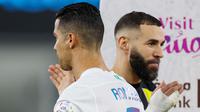 Pemain Al Nassr, Cristiano Ronaldo, berpapasan dengan pemain Al Ittihad, Karim Benzema, dalam laga tunda pekan ke-17 Liga Arab Saudi di King Abdullah Sport City Stadium, Jeddah, Rabu (27/12/2023). Al Nassr menang dengan skor 5-2. (Photo by AFP)