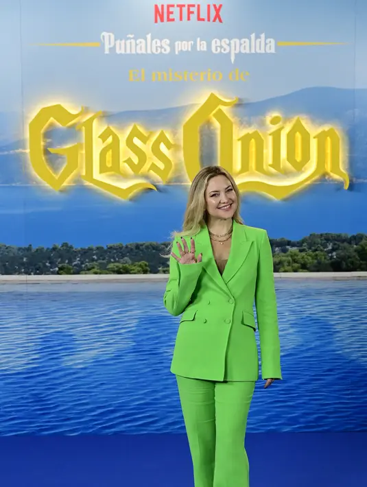 Kate Hudson melambaikan tangan saat tiba menghadiri pemutaran perdana film "Glass Onion: a knife out misteri" di Madrid, pada 19 Oktober 2022. Ia menambah tinggi tubuhnya dengan sepasang sepatu hak tinggi. (AFP/Javier Soriano)