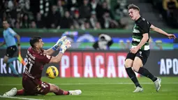 Pemain Sporting CP, Viktor Gyokeres (kanan) berusaha mencetak gol ke gawang Estoril Praia ditepis oleh kiper Joel Robles dalam laga lanjutan Liga Portugal 2024/2025 di Stadion Jose Alvalade, Lisbon, Portugal, Senin (03/03/2025) waktu setempat. (AFP/Patricia De Melo Moreira)