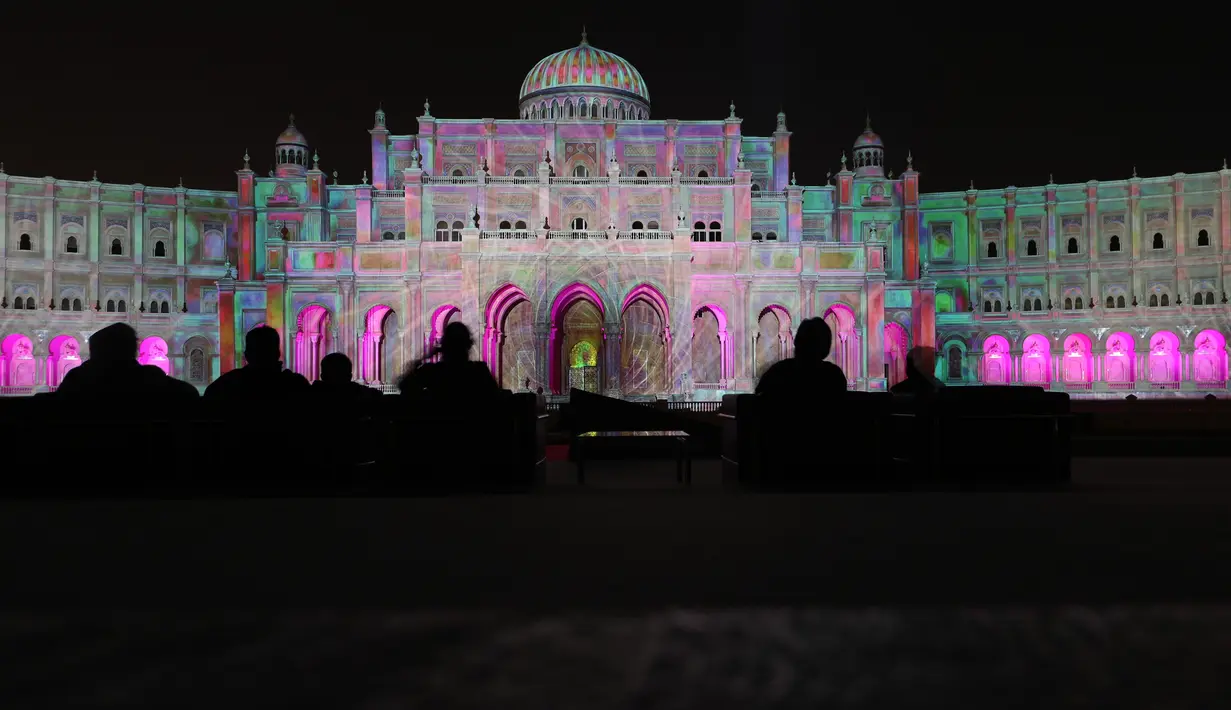 Pengunjung mengambil gambar bangunan ikonik kota Sharjah yang diterangi lampu warna-warni selama festival cahaya Sharjah di Uni Emirat Arab, 13 Februari 2019. Festival cahaya tahunan ini menampilkan kombinasi desain cahaya tiga dimensi. (KARIM SAHIB/AFP)