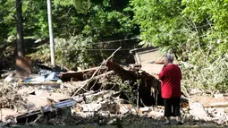 Emma Allen (58) mengamati puing rumahnya yang dilanda banjir dahsyat di Falling Rock, Virginia Barat, Minggu (26/6). Status darurat sudah dinyatakan di 44 dari 55 wilayah setingkat kota di negara bagian tersebut. (REUTERS/Marcus Constantino)