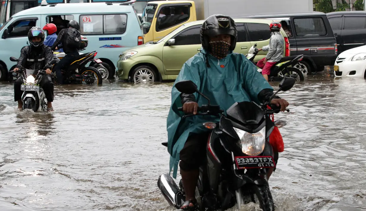 Sejumlah kendaraan bermotor nekat melintasi Jalan Matraman, Jakarta,  yang digenangi air, Sabtu (27/12/2014). (Liputan6.com/Miftahul Hayat)