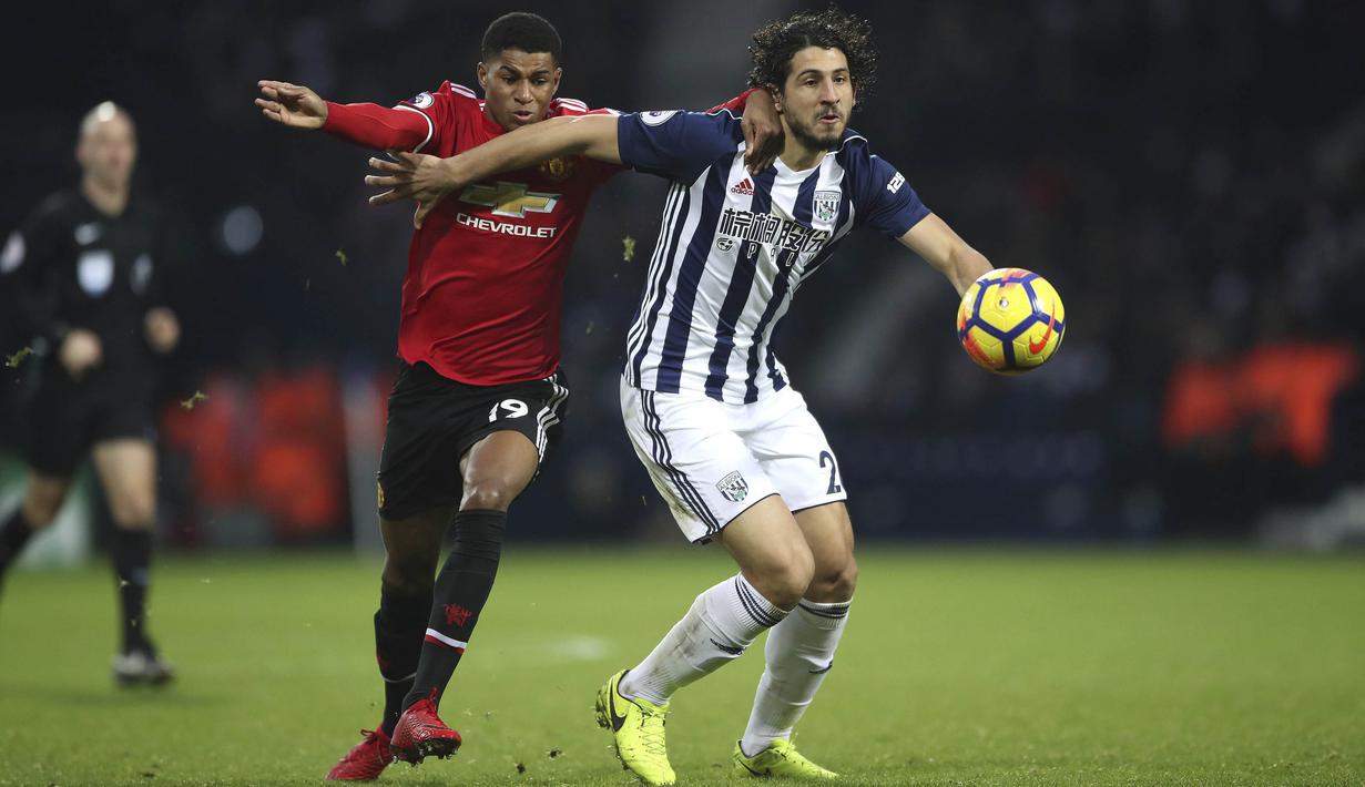 Gelandang Manchester United (MU), Marcus Rashford, berebut bola dengan bek West Bromwich Albion (WBA), Ahmed Hegazi, pada laga Premier League di Stadion The Hawthorns, Minggu (17/12/2017). MU menang 2-1 atas WBA. (AP/Nick Potts)