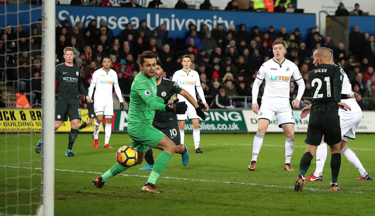 Pemain Manchester City, David Silva berhasil mencetak gol ke gawang Swansea City pada lanjutan Premier League, di Liberty Stadium, Rabu (13/12). Man City mencatatkan rekor 15 kemenangan berturut-turut usai menang dengan skor 4-0. (Nick Potts/PA via AP)