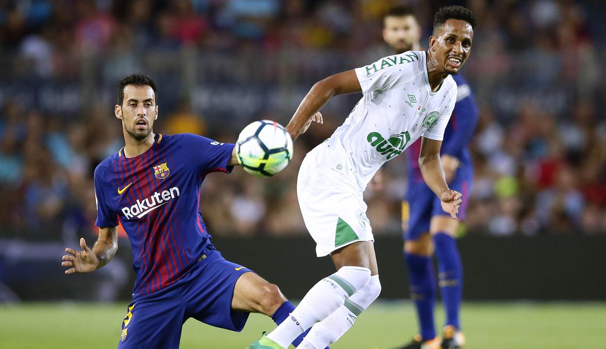 Gelandang Barcelona, Sergio Busquets, berebut bola dengan gelandang Chapecoense, Lucas Mineiro,  pada laga trofi Joan Gamper di Stadion Camp Nou, Barcelona, Senin (7/8/2017). Barcelona menang 5-0 atas Chapecoense. (AP/Manu Fernandez)