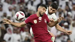 Pemain Qatar, Mohammed Waad (kiri) berduel udara dengan pemain Iran, Alireza Jahanbakhsh pada laga semifinal Piala Asia 2023 di Al Thumama Stadium, Doha, Qatar, Rabu (07/02/2024). (AFP/Hector Retamal)