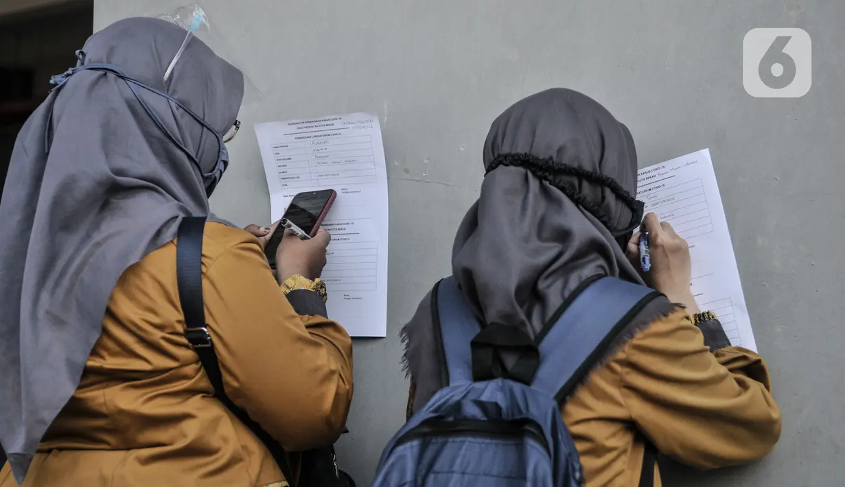 Warga mengisi data diri sebelum mengikuti rapid test Covid-19 di Stadion Patriot Candrabhaga, Bekasi, Rabu (23/9/2020). Rapid test yang digelar secara gratis oleh Pemkot Bekasi tersebut mampu memeriksa hingga 150 orang tiap harinya guna melacak kasus Covid-19 di Bekasi. (merdeka.com/Iqbal Nugroho)