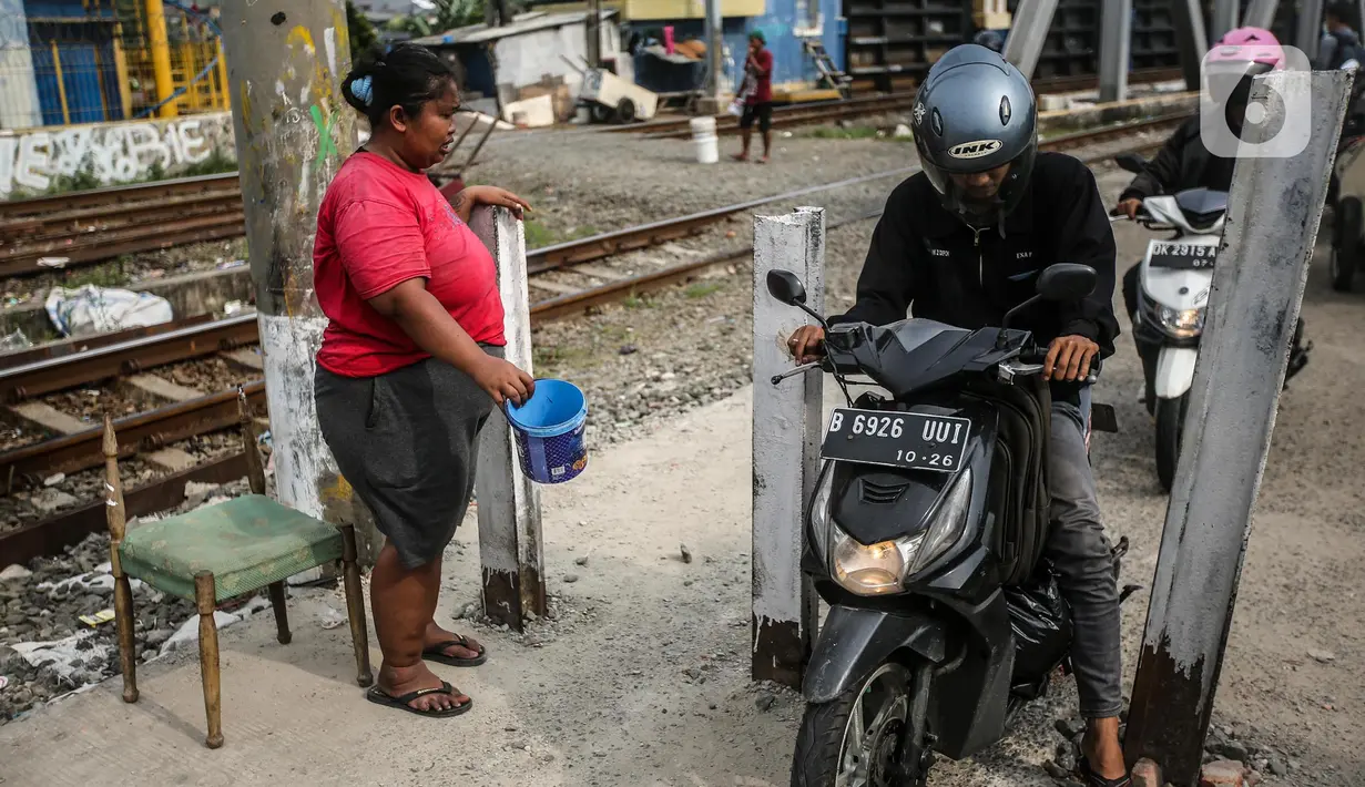Kendaraan roda dua tetap melintas walaupun sudah ditutup di perlintasan kereta api di kawasan Tanah Abang-Palmerah Jakarta, Jumat (24/6/2022). PT Kereta Api Indonesia (Persero) atau KAI Daop 1 Jakarta menutup enam perlintasan liar sebagai upaya mewujudkan keselamatan dan keamanan perjalanan KA serta masyarakat.  (Liputan6.com/Faizal Fanani)