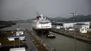Sebuah kapal kecil menarik kapal pesiar Disney Wonder untuk melintasi terusan Panama, Panama (29/4). Saat ini kapal pesiar atau Disney Cruise Line mengoperasikan empat kapal, salah satunya adalah Disney Wonder. (AFP Photo/Rodrigo Arangua)