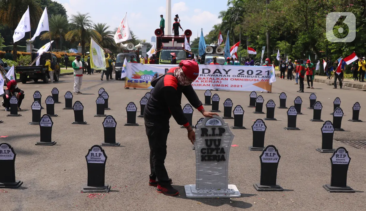 Buruh meletakkan puluhan nisan di sekitar area Monas, Jakarta, pada Hari Buruh Internasional, Sabtu (1/5/2021). Nisan hitam itu dihiasi tulisan yang mewakili perasaan para buruh, Antara lain RIP PHK Murah, Bebasnya Outsourcing, RIP Cuti Hamil, RIP Satuan Upah-Perjam. (Liputan6.com/Angga Yuniar)