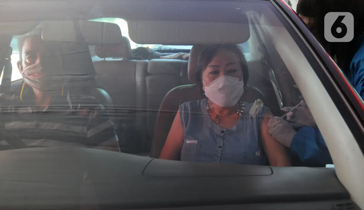 Paramedis menyuntikkan vaksin COVID-19 secara drive thru kepada penumpang mobil di GOR Pajajaran, Kota Bogor, Jawa Barat, Rabu (17/3/2021). Kegiatan ini menargetkan 600 warga per hari dan berlangsung hingga tiga bulan ke depan. (merdeka.com/Arie Basuki)