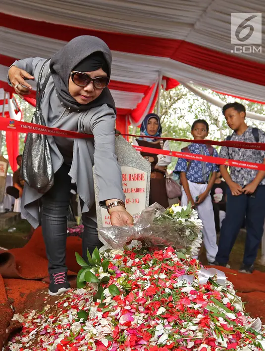 Warga meletakkan bunga di atas makam Presiden ketiga RI BJ Habibie di TMP Kalibata, Jakarta, Kamis (12/9/2019). Tidak hanya dihadiri tokoh penting, ratusan warga juga antusias datang ke TMP Kalibata untuk mengantarkan BJ Habibie ke tempat peristirahatan terakhirnya. (Liputan6.com/Herman Zakharia)