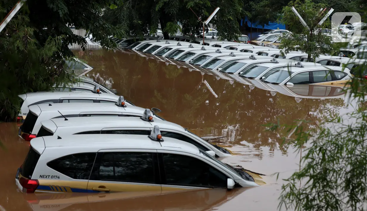 Kondisi dan suasana Pool Taksi Express di kawasan Tanah Kusir yang terendam banjir, Jakarta, Rabu (1/1/2020). Banjir akibat hujan deras yang mengguyur Jakarta dan sekitarnya sejak Selasa sore (31/12/2019) menyebabkan ratusan armada taksi terendam. (Liputan6.com/Johan Tallo)