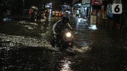 Pengendara motor menerobos genangan banjir di kawasan Kemang, Jakarta, Selasa (4/10/2022). Jalan Kemang Utara IX tak bisa dilalui oleh kendaraan. Banjir menggenangi kawasan Pasar Kambing dan sejumlah rumah penduduk. (Liputan6.com/Faizal Fanani)