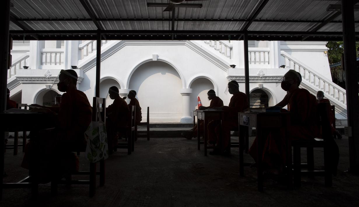 Para biksu muda mengenakan masker dan pelindung wajah saat belajar agama di Molilokayaram Educational Institute, Bangkok, Thailand, Rabu (15/4/2020). Sekitar 200 biksu muda tetap bersekolah kendati Thailand menutup semua sekolah selama lockdown akibat COVID-19. (AP Photo/Gemunu Amarasinghe)
