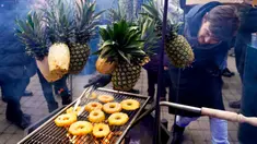 Seorang pria memanggang irisan nanas saat Riga Street Food Festival di Riga, Latvia, Sabtu (18/1/2020). Api unggun dan kios-kios makanan didirikan di sudut Jalan Kalku dan Valnu di Kota Tua Riga agar pengunjung dapat menikmati berbagai hidangan populer dari kota tersebut. (Xinhua/Janis)