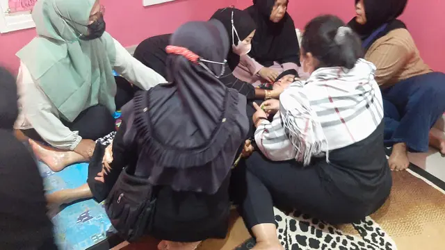 Ibu dari DAL, korban tembok roboh MTSN 19 Jakarta, Yusnia pingsan usai dari pemakaman. (Merdeka/Lydia Fransisca)