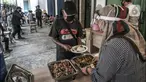 Warga mengambil makanan gratis di Jalan Basuki Rachmat, Cipinang Muara, Jakarta, Senin (8/3/2021). Sejak Juli 2020, Hadi (40) dibantu teman-temannya menggelar layanan makan gratis kepada warga