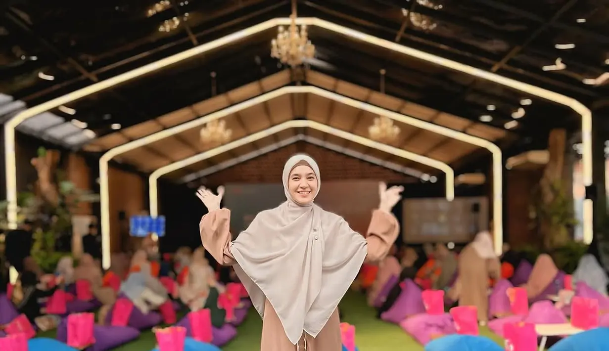 Untuk tampilan yang lebih simple, Dhini Aminarti padukan gamis dan hijab segitiga yang panjang [@dhiniaminarti]