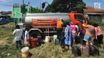Warga antre mengambil air bersih bantuan Badan Penanggulangan Bencana Daerah (BPPD) Kabupaten Bogor di Pabuaran, Ciampea, Bogor, Jawa Barat, Senin (6/8). Kemarau menyebabkan sejumlah wilayah kekeringan dan kesulitan air bersih. (Merdeka.com/Arie Basuki)