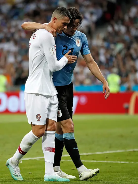 Penyerang Portugal, Cristiano Ronaldo memapah Penyerang Uruguay, Edinson Cavani yang Cedera keluar lapangan saat pertandingan babak 16 besar Piala Dunia 2018 di Stadion Fisht di Sochi, Rusia (30/6).  (AP Photo/Francisco Seco)