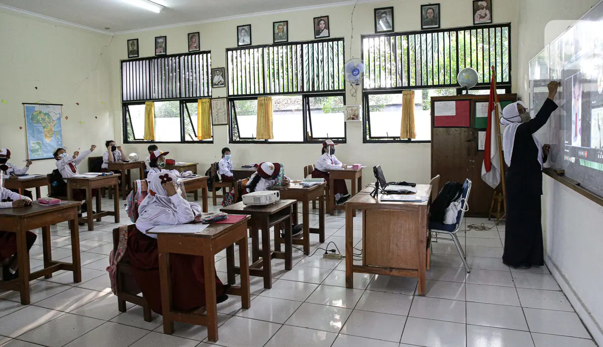 Guru memberikan materi pelajaran saat hari pertama uji coba pembelajaran tatap muka di SD Negeri 14 Pondok Labu, Jakarta, Senin (30/8/2021). Pemprov DKI melalui Dinas Pendidikan Provinsi DKI Jakarta memberlakukan sekolah tatap muka terbatas tahap 1 sebanyak 610 sekolah. (Liputan6.com/Faizal Fanani)