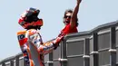 Pembalap Repsol Honda, Marc Marquez memanjat pagar lintasan setelah berhasil finis pertama pada balapan MotoGP Spanyol 2018 di Sirkuit Jerez, Minggu (6/5). Marquez mengukir waktu 41 menit 39,678 detik. (AP Photo/Miguel Morenatti)