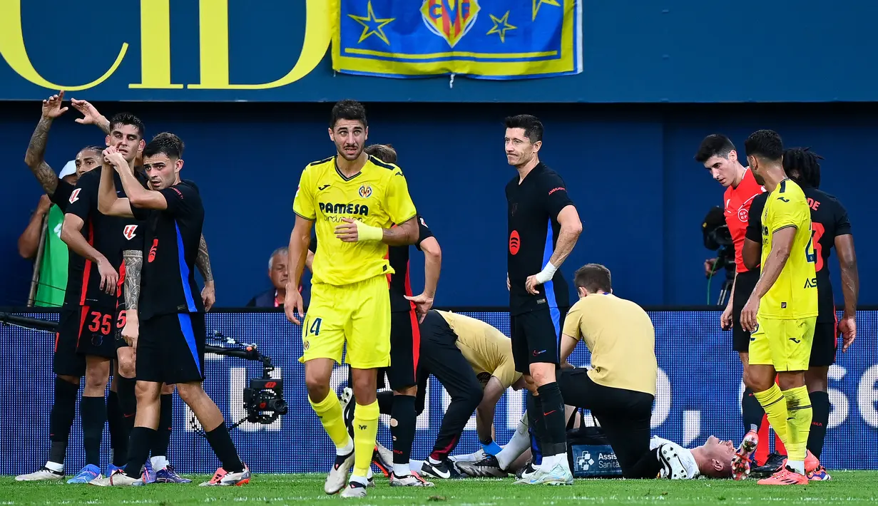 Marc-Andre Ter Stegen langsung mendapatkan bantuan medis usai dirinya merasa kesakitan ketika menghadapi Villarreal di Stadion La Ceramica pada Minggu (22/9/2024). Ter Stegen mengalami cedera lutut yang terlihat cukup parah di babak pertama. (AFP/Jose Jordan)
