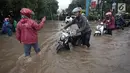Para pengendara mendorong motornya saat melintasi banjir di Jalan Boulevard Barat Raya, Kelapa Gading, Jakarta, Kamis (15/2). Hujan lebat sejak pagi hingga sore hari mengakibatkan sejumlah wilayah Ibu Kota terendam banjir. (Liputan6.com/Arya Manggala)
