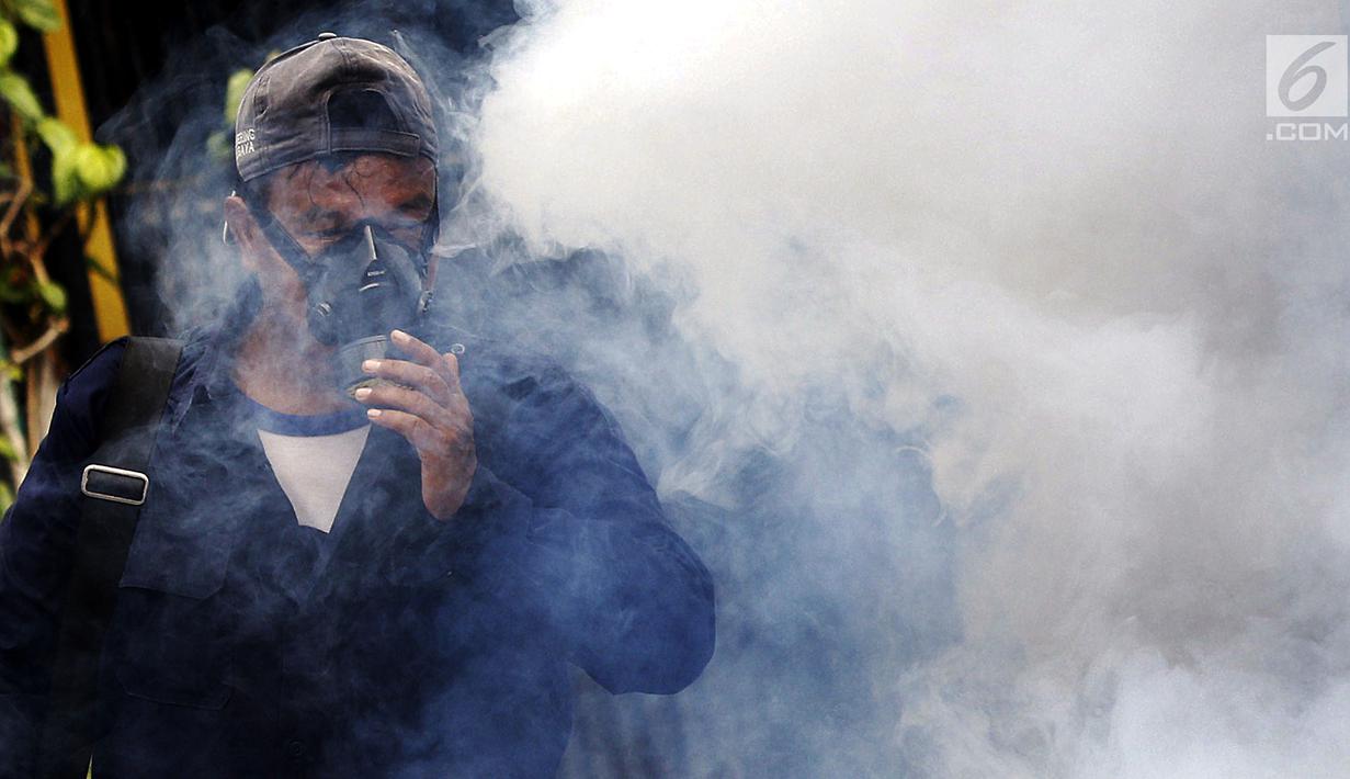 Petugas melakukan pengasapan atau fogging di permukiman warga di Jalan Delima Raya, Jakarta Barat, Selasa (30/4/2019). Pengasapan tersebut untuk mencegah penyebaran penyakit Demam Berdarah Dengue (DBD) melalui nyamuk Aedes Aegypti saat musim hujan mulai terjadi di Jakarta. (Liputan6.com/Johan Tallo)