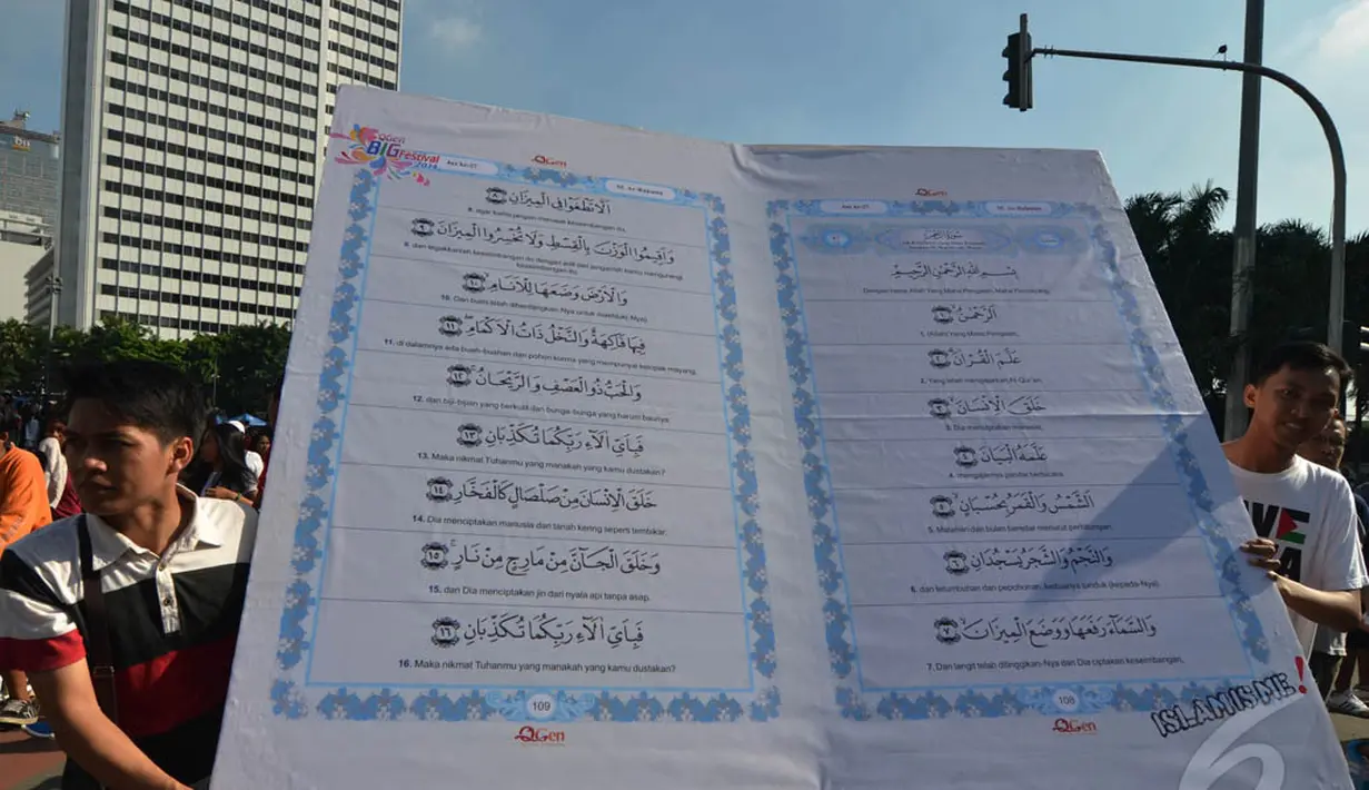 Aktivis yang tergabung dalam Quran Generation membawa Alquran raksasa di Bundaran HI, Jakarta, Minggu (21/12/2014). (Liputan6.com/Herman Zakharia)