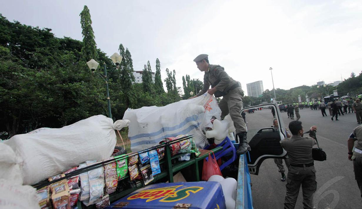 Petugas saat mengangkut barang dagangan PKL ke dalam truk kendaraan operasional dinas, Jakarta, Kamis (4/12/2014). (Liputan6.com/Faizal Fanani)