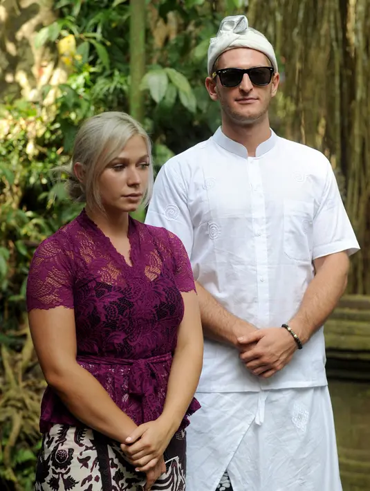 Turis Ceko, Sabina Dolezalova (kiri) dan Zdenek Slouka saat akan mengikuti upacara guru piduka di Pura Beji, Ubud, Bali, Kamis (15/8/2019). Kabarnya, banyak masyaraat Bali yang merasa kurang puas atas permintaan maaf Sabina dan Zdenek setelah mereka berulah di Pura Beji. (SONNY TUMBELAKA/AFP)
