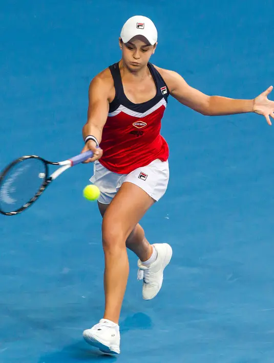 Petenis Ashleigh Barty mengembalikan bola pukulan petenis Spanyol, Garbine Muguruza selama pertandingan tunggal putri hari kelima turnamen tenis Piala Hopman di Perth (3/1). Ashleigh Barty asal Australia berusia 22 tahun. (AFP Photo/Tony Ashby)